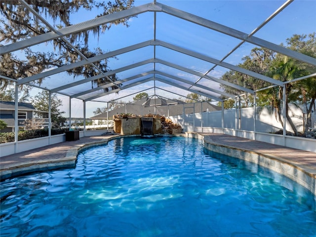 view of swimming pool featuring glass enclosure and a patio area