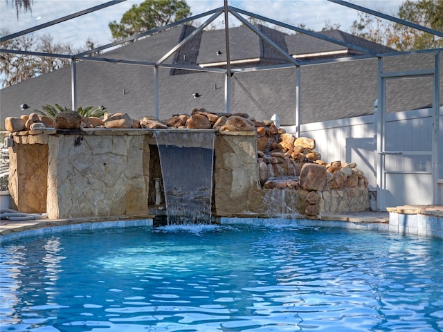 view of pool with a lanai and pool water feature