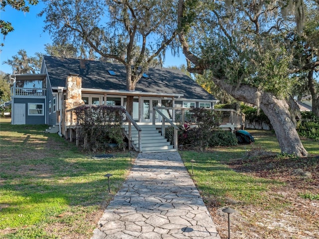 view of front of property featuring a deck and a front lawn