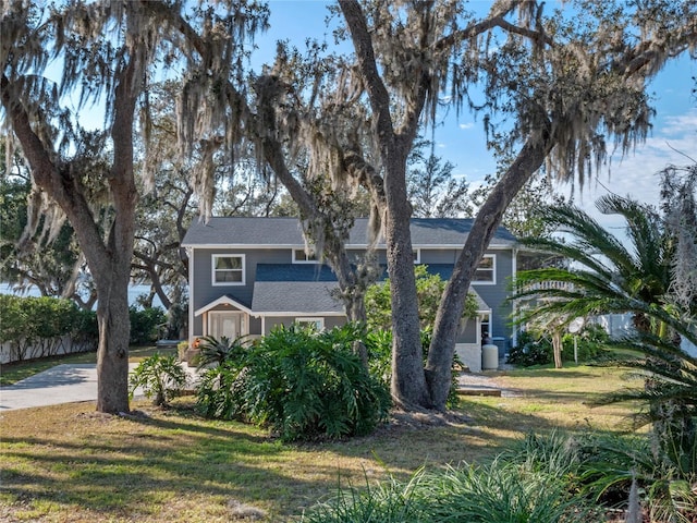 view of property hidden behind natural elements with a front lawn