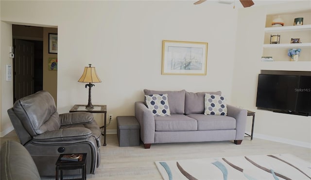 living room featuring built in features and ceiling fan