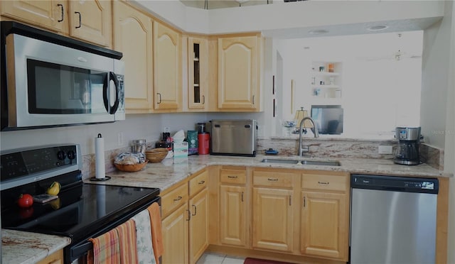 kitchen featuring light stone counters, light brown cabinetry, sink, and appliances with stainless steel finishes