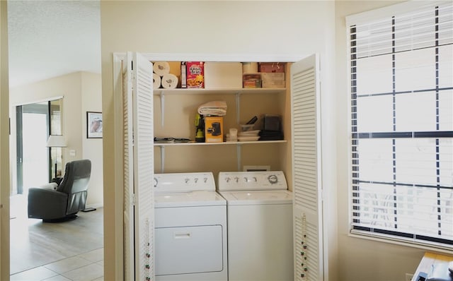 laundry area with washing machine and dryer and light tile patterned floors