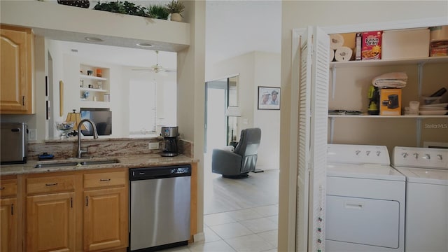 kitchen with ceiling fan, sink, separate washer and dryer, stainless steel dishwasher, and light tile patterned floors