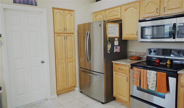 kitchen featuring appliances with stainless steel finishes, light brown cabinets, and light tile patterned floors