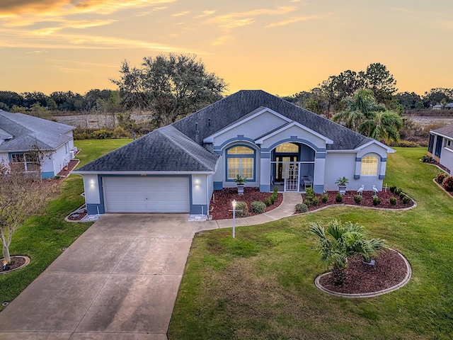 ranch-style house with a lawn, french doors, and a garage