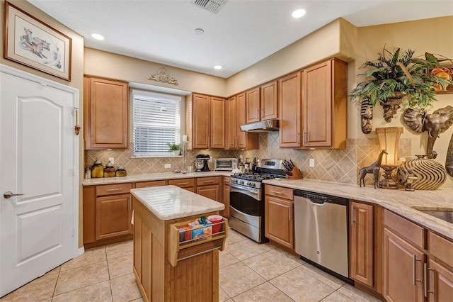 kitchen featuring decorative backsplash, a center island, light tile patterned flooring, and appliances with stainless steel finishes