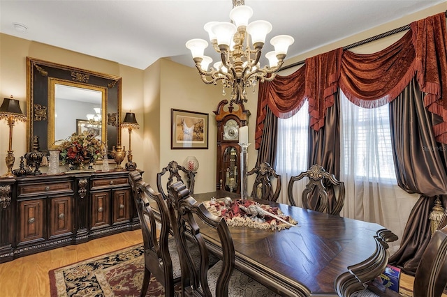 dining room featuring light wood-type flooring and a chandelier