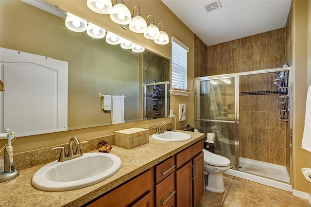 bathroom with tile patterned floors, vanity, toilet, and walk in shower