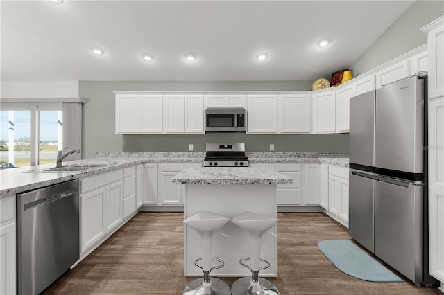 kitchen with white cabinetry, stainless steel appliances, and a kitchen island