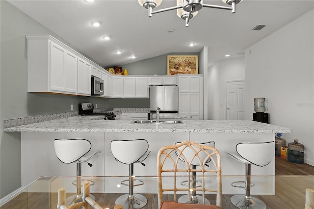 kitchen featuring kitchen peninsula, sink, white cabinetry, a breakfast bar area, and stainless steel appliances