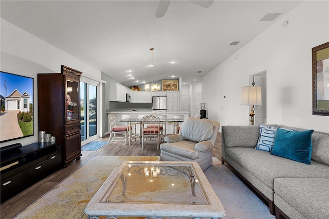 living room with ceiling fan, dark hardwood / wood-style flooring, and vaulted ceiling