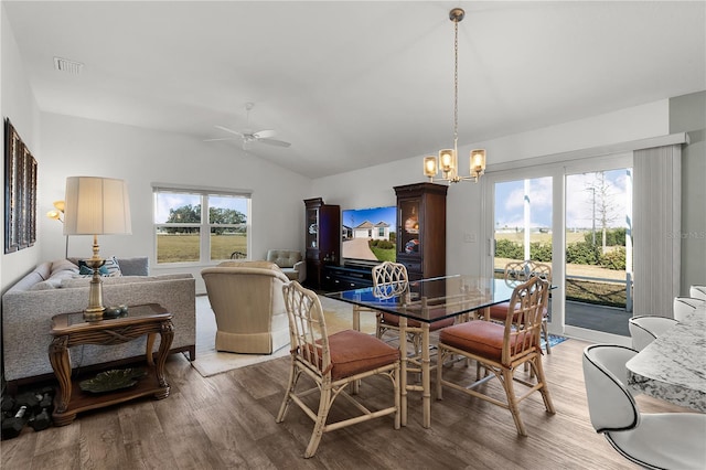 dining room featuring lofted ceiling, wood-type flooring, and ceiling fan with notable chandelier