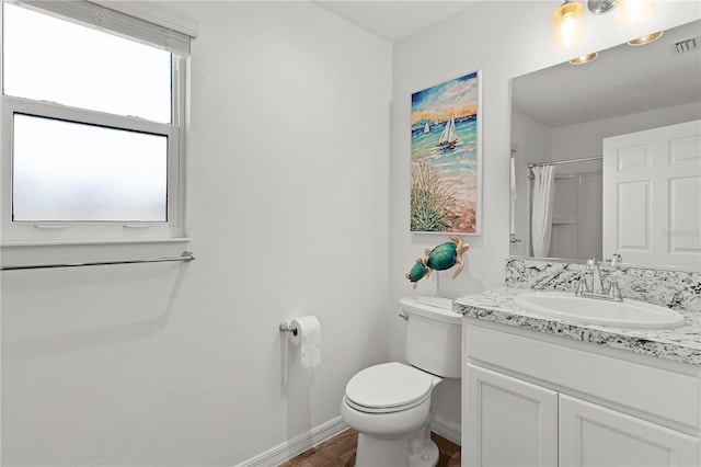 bathroom featuring wood-type flooring, toilet, walk in shower, and vanity