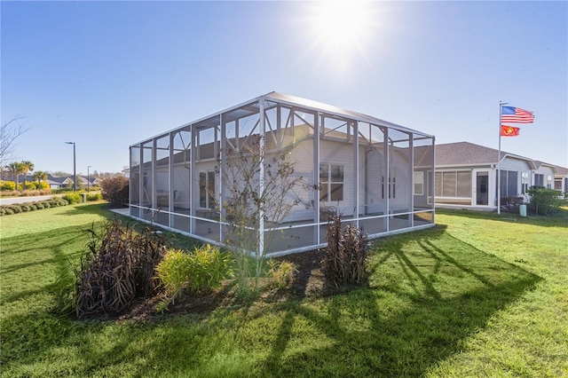 rear view of property with a lanai and a lawn