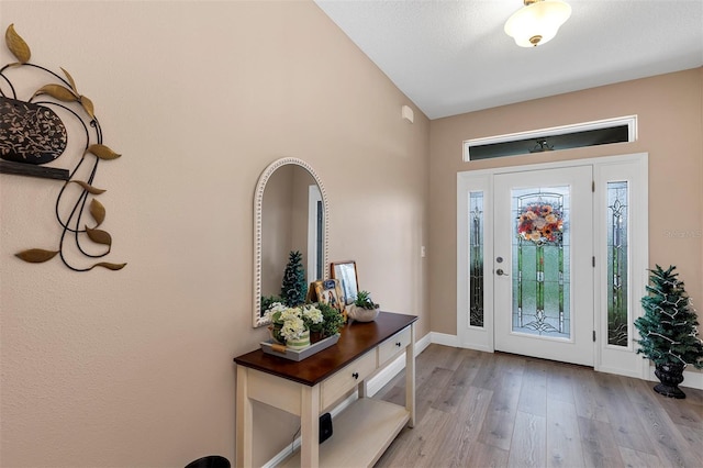 entrance foyer with vaulted ceiling and light hardwood / wood-style flooring