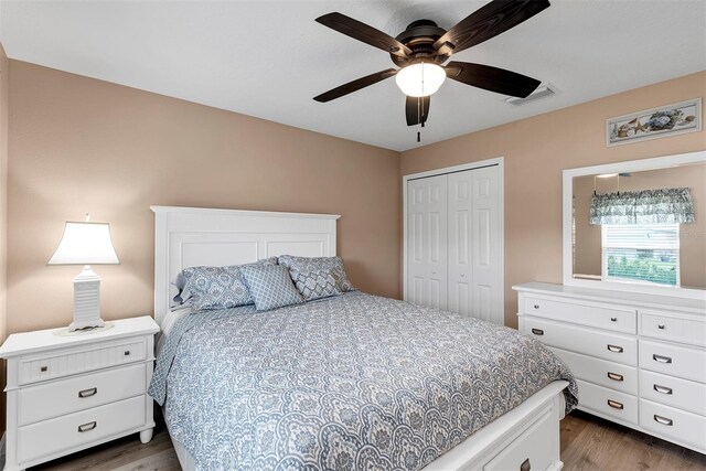 bedroom featuring ceiling fan, dark hardwood / wood-style floors, and a closet