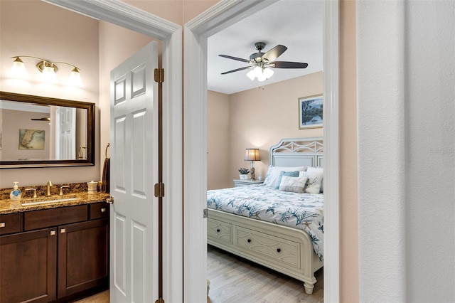 bedroom with ceiling fan, sink, and light hardwood / wood-style floors