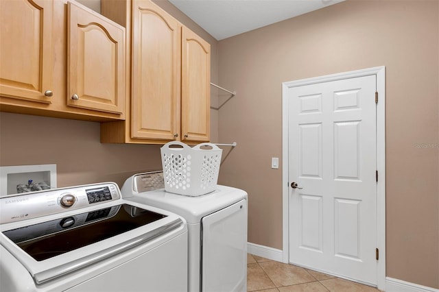 washroom with cabinets, light tile patterned floors, and washing machine and dryer