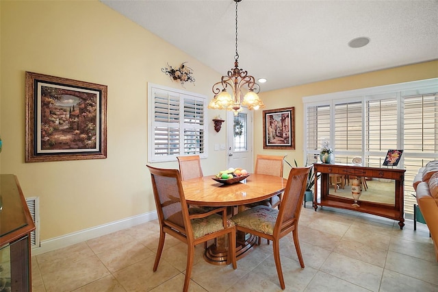 tiled dining room featuring lofted ceiling, plenty of natural light, and a chandelier