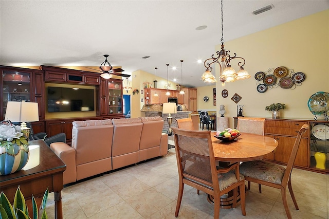 dining area featuring lofted ceiling, light tile patterned floors, and ceiling fan with notable chandelier