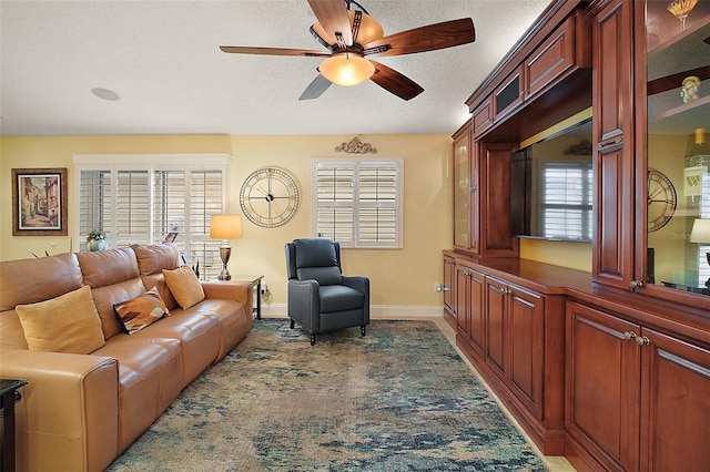 living room featuring ceiling fan, a healthy amount of sunlight, and a textured ceiling