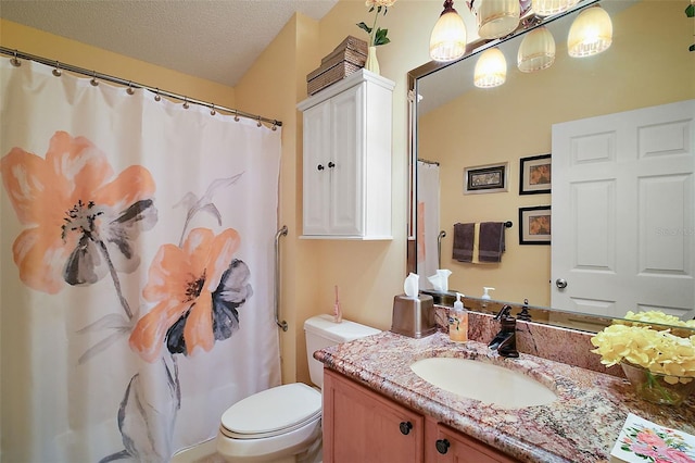 bathroom featuring toilet, vanity, and a textured ceiling