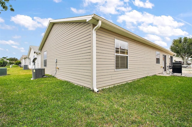 view of home's exterior featuring central AC unit and a yard