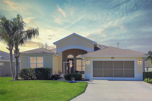 ranch-style home with a garage and a lawn