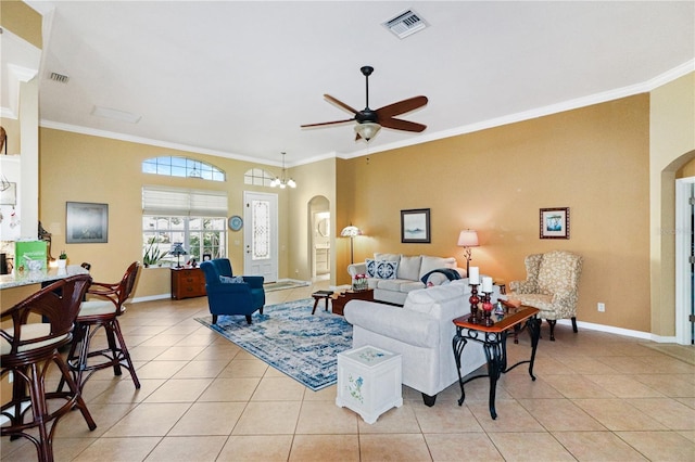 tiled living room with ceiling fan with notable chandelier and ornamental molding