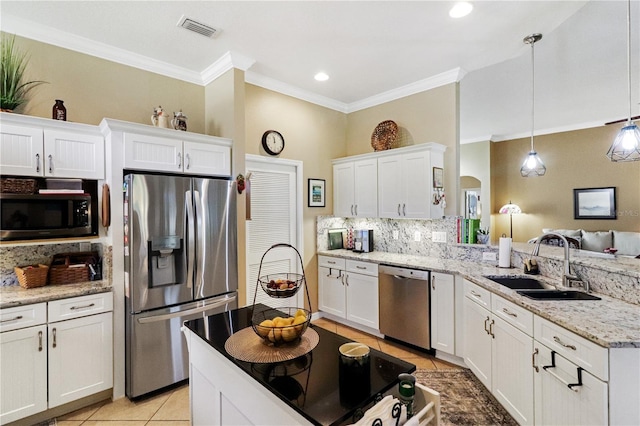 kitchen with white cabinets, sink, decorative backsplash, appliances with stainless steel finishes, and decorative light fixtures