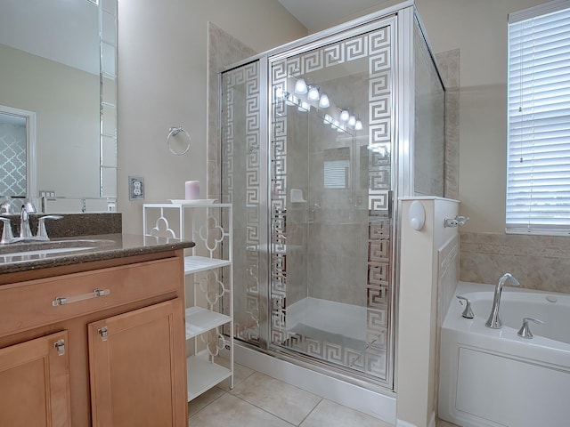 bathroom featuring plus walk in shower, vanity, and tile patterned floors