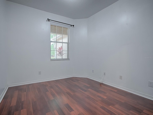 unfurnished room with dark wood-type flooring