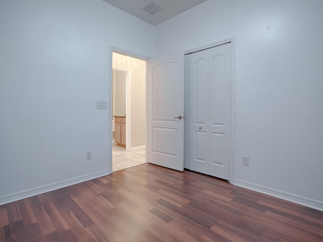 unfurnished bedroom with light wood-type flooring and a closet