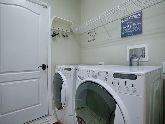 laundry room with light tile patterned flooring and washing machine and dryer