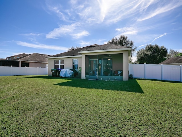 back of property featuring a sunroom and a yard