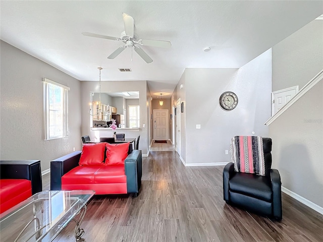 living room featuring hardwood / wood-style floors and ceiling fan with notable chandelier