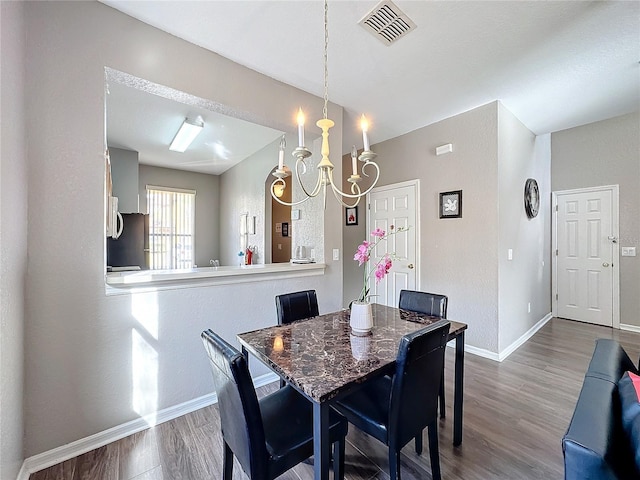 dining area with a notable chandelier and hardwood / wood-style flooring