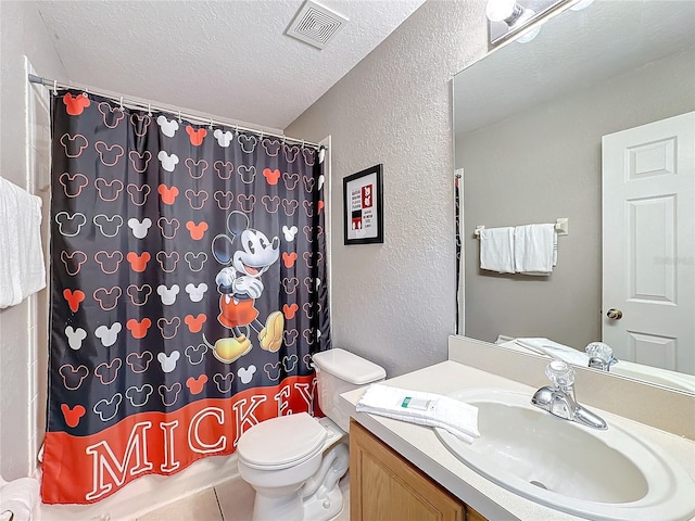 bathroom with tile patterned floors, vanity, a textured ceiling, toilet, and curtained shower