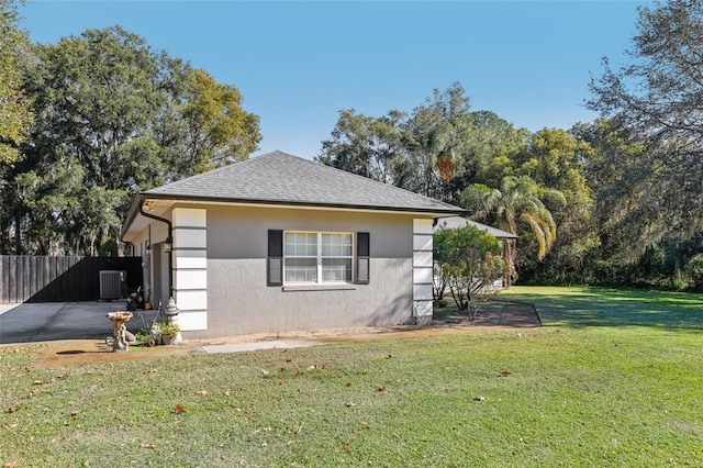 view of side of home featuring a lawn and cooling unit