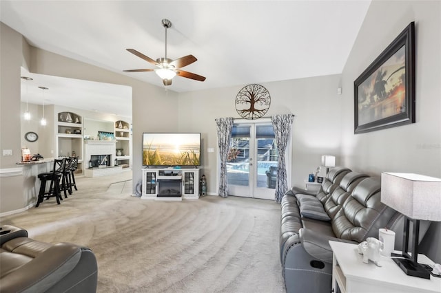 living room featuring light carpet, built in shelves, ceiling fan, and lofted ceiling