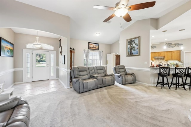 living room featuring ceiling fan, lofted ceiling, and light carpet