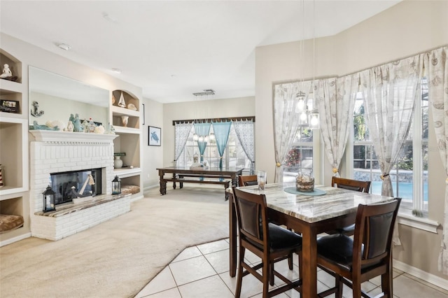 dining area with built in shelves, light colored carpet, a brick fireplace, and plenty of natural light