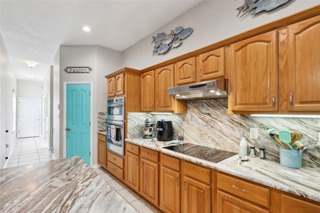 kitchen with light stone countertops, black electric stovetop, light tile patterned flooring, and stainless steel double oven