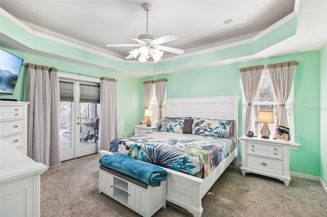 carpeted bedroom with access to outside, ceiling fan, and a tray ceiling