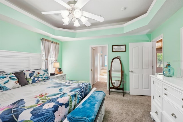 carpeted bedroom with ceiling fan and a raised ceiling