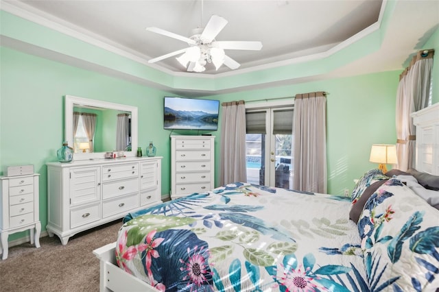 carpeted bedroom with access to exterior, a raised ceiling, and ceiling fan