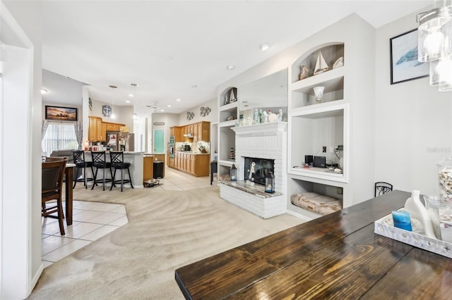 tiled living room featuring built in shelves and a brick fireplace