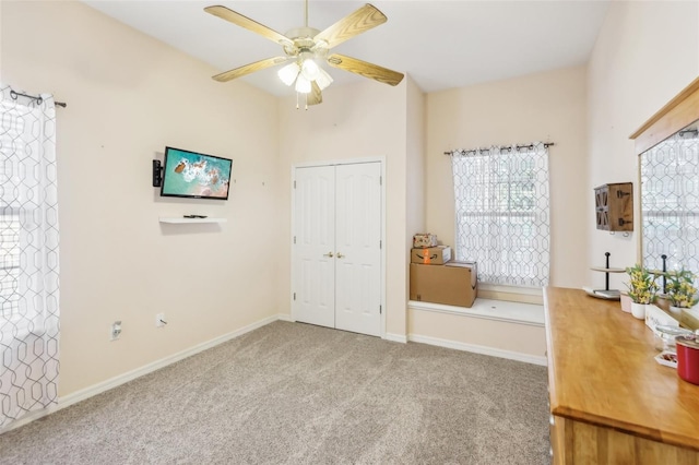 carpeted bedroom with ceiling fan and a closet