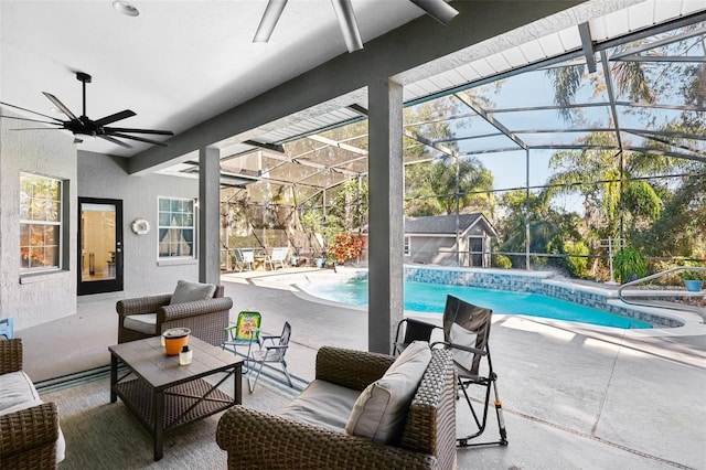 view of pool featuring outdoor lounge area, glass enclosure, ceiling fan, and a patio area